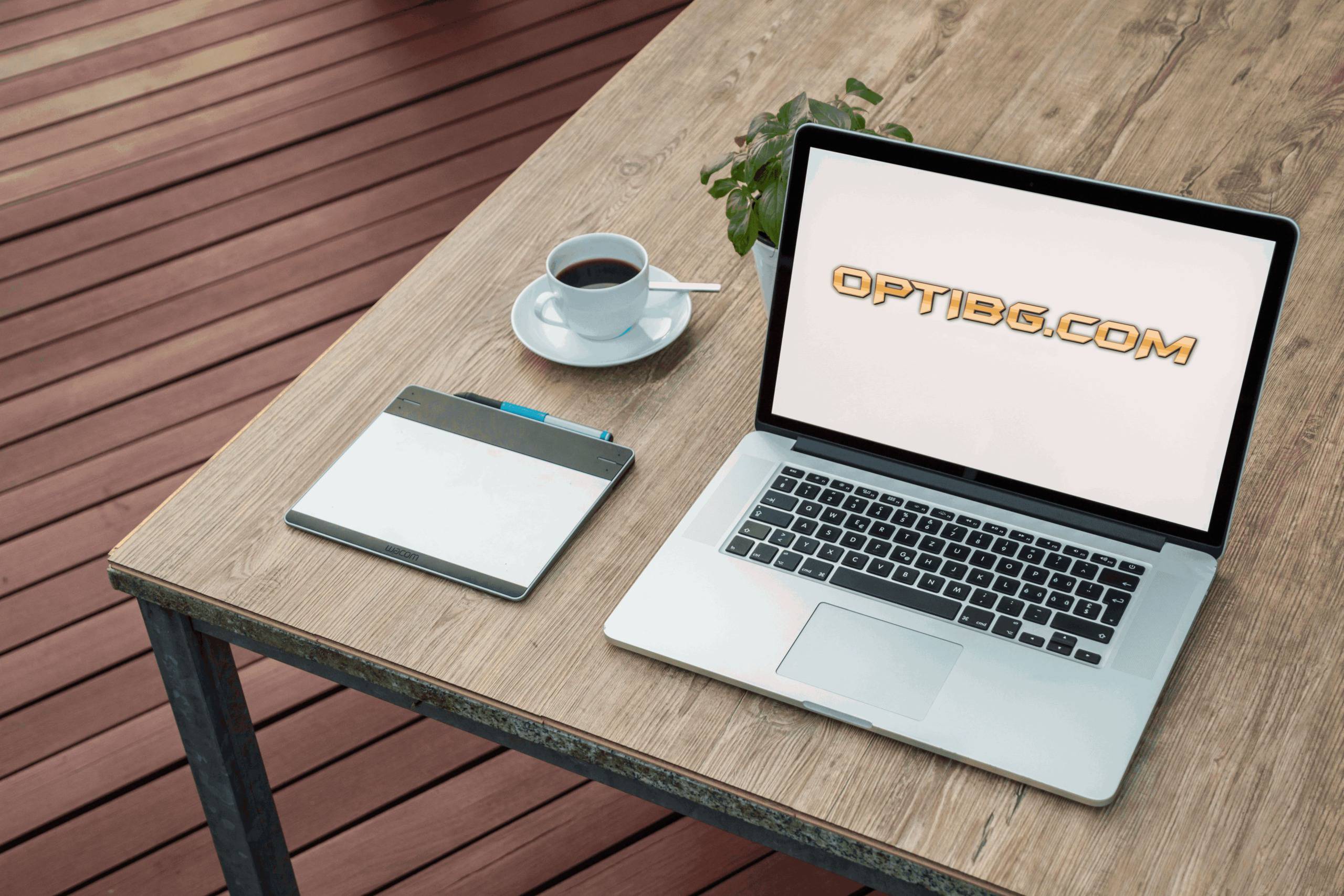 Лаптоп с логото на Optibg.com върху дървено работно бюро до чаша кафе